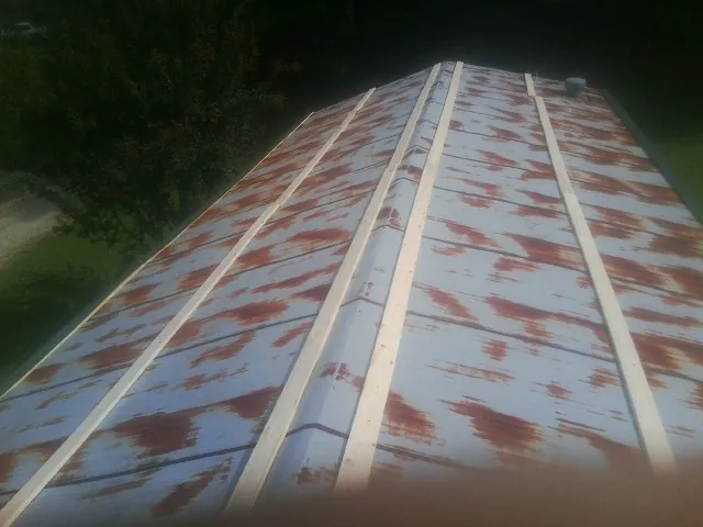 Rusted metal roof panels with new wood purlins before replacement — Storm Damage Roof Repair in Roslindale by Roofing Brothers