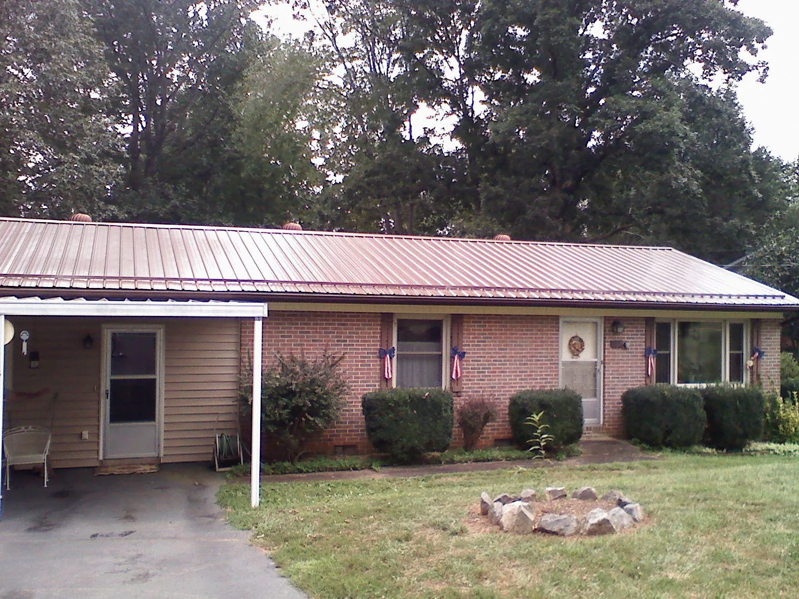 Bronze metal roof and carport on a brick ranch home — Roof Repair work by our crew in Roslindale